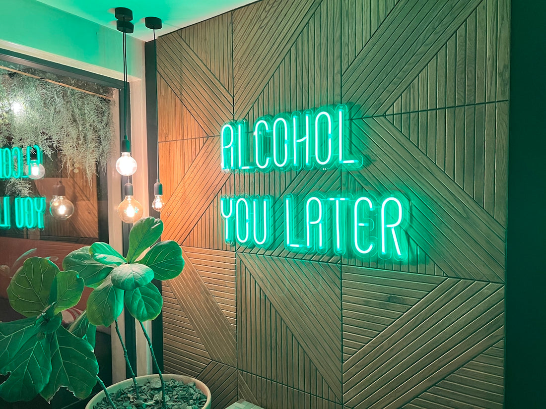 a green neon sign that reads alcohol you later
