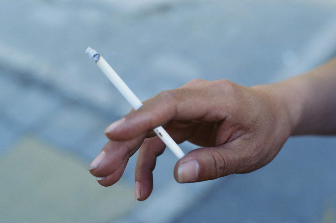 a person holding a cigarette in their hand
