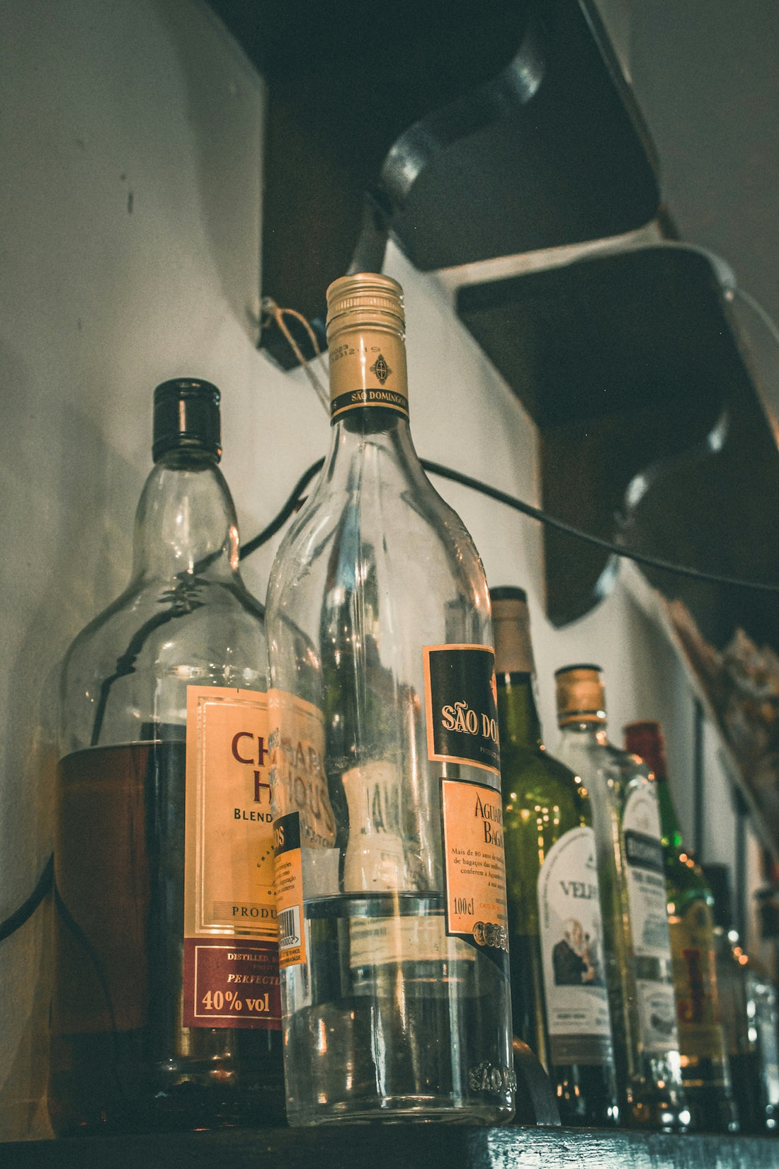 Several bottles of alcohol on a shelf